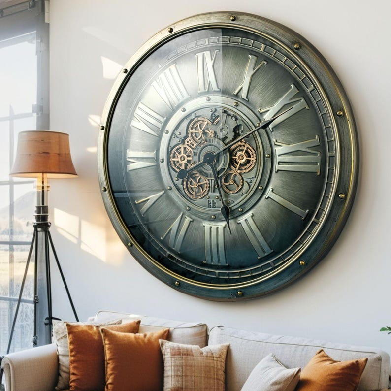 May include: Large, round wall clock with a metallic gray finish and Roman numerals. The clock features visible gears in the center and a glass cover. The clock is mounted on a white wall above a sofa with orange and beige pillows.