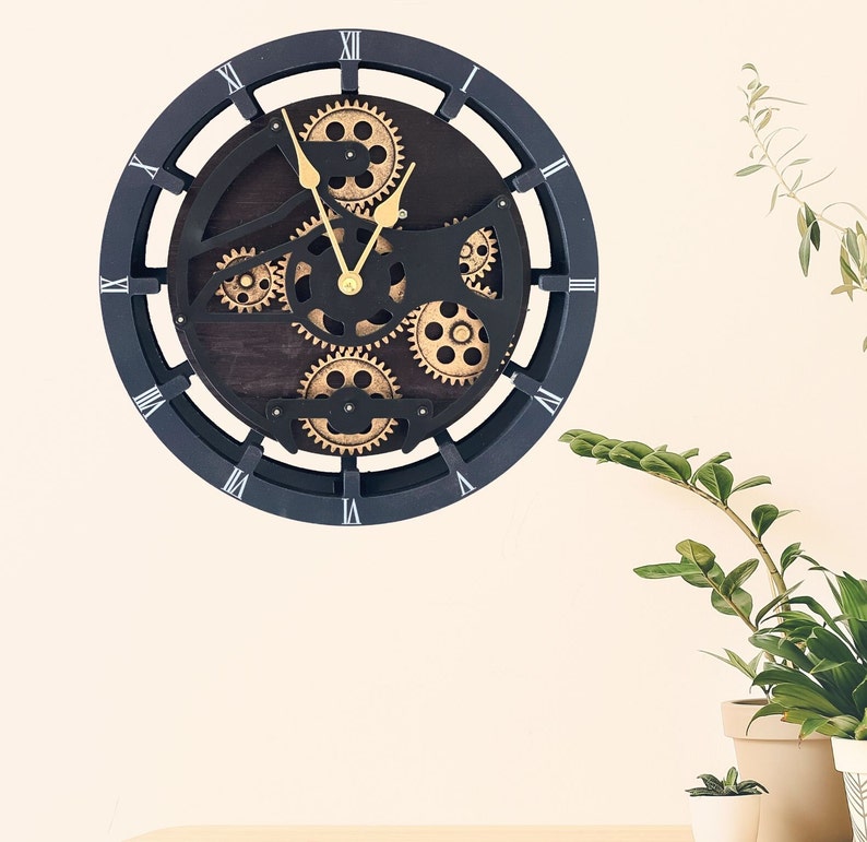May include: Black clock with Roman numeral markings and a steampunk design featuring gears and cogs. The clock face is made of wood and has a distressed look.
