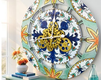 May include: A large round wall clock featuring a white face with blue and orange floral patterns and exposed gold-colored mechanical gears in the center. The outer frame displays a repeating painted motif of orange flowers and green leaves.