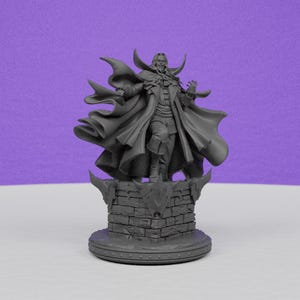May include: A gray figurine of a vampire with a long coat and cape, standing on a brick-like pedestal. The vampire has a stern expression and is posed with outstretched arms. The background is a solid purple.