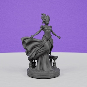May include: A gray figurine of a woman in a flowing gown, arms outstretched. She wears a feathered headdress and stands on a circular base with a small bench behind her. The background is a solid purple.
