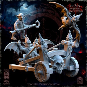 May include: A grey plastic miniature of a goblin riding a catapult with a skull on the front. The catapult has a chain and two wooden posts. The goblin is wearing a helmet and has wings. The text "One Sin for Seven Kingdoms" is visible in the background.