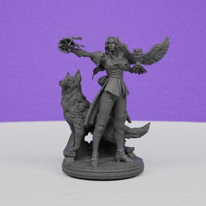 May include: A gray figurine of a woman with an owl on her arm and a wolf beside her. The woman is wearing a tunic and pants. The owl has its wings spread. The wolf is standing on its hind legs. The figurine is on a round base.