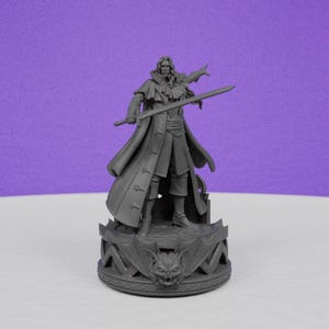 May include: A gray figurine of a man in a long coat, holding a sword, and standing on a decorative base. The base features a dragon-like face and ornate detailing. The figure is set against a purple background.