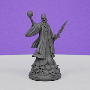 May include: A gray figurine of a skeletal king holding a sphere and a sword. The king wears a crown and flowing robes, standing atop a base with skulls. The background is a solid purple.
