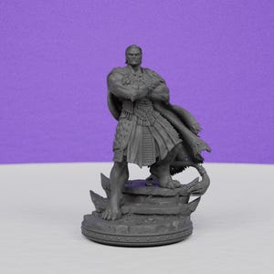 May include: A gray figurine of a muscular figure with crossed arms, wearing a detailed outfit and cape. The figure stands on a rocky base with a circular bottom, set against a purple backdrop.