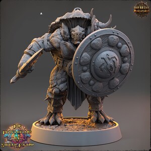 May include: A gray, detailed miniature of a turtle-like creature with a large shield and a spear. The creature has a shell-like head and a large, round shield with intricate designs. The miniature is standing on a round base.