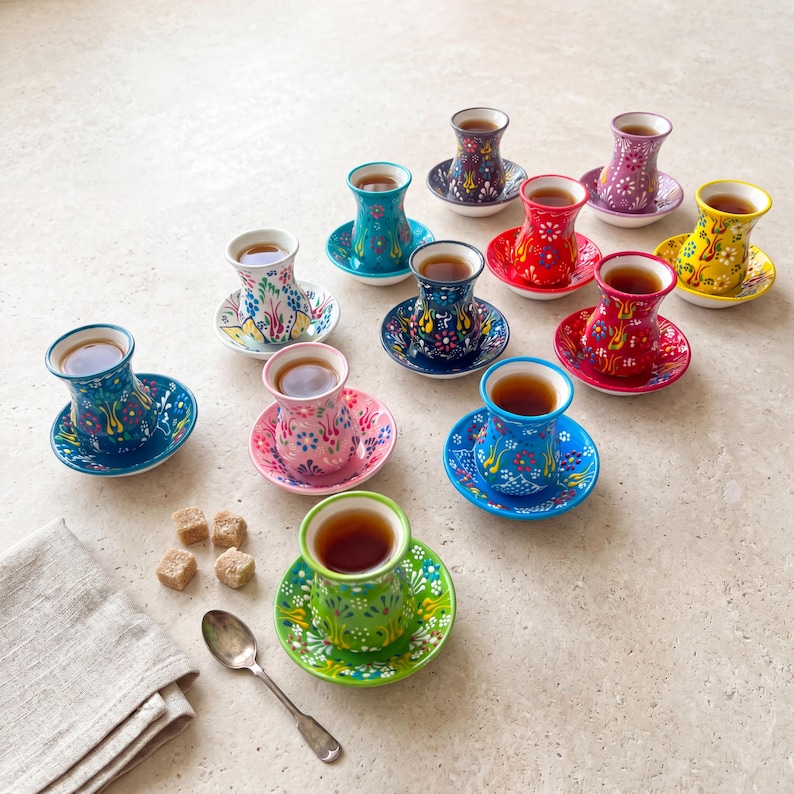 Mix and match tea cups set with saucers on a neutral table, handmade ceramic tea cups in colorful designs for Turkish tea, tea gifts, and daily tea rituals.