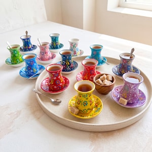 Handmade ceramic Turkish tea set displayed on a large serving tray with tea, sugar cubes, spoons, and colorful tea cups and saucers for tea party styling.