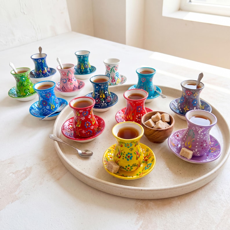 Handmade ceramic Turkish tea set displayed on a large serving tray with tea, sugar cubes, spoons, and colorful tea cups and saucers for tea party styling.