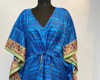 May include: A blue and white patterned kaftan with a V-neck and a drawstring waist. The kaftan has a green and gold trim.