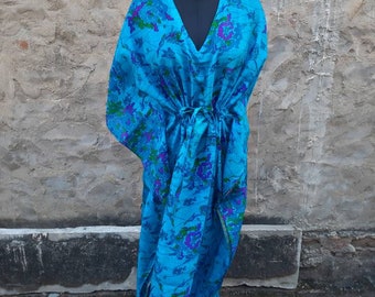 May include: A blue and purple floral print kaftan with a V-neck and long sleeves. The kaftan is tied at the waist with a matching fabric belt.