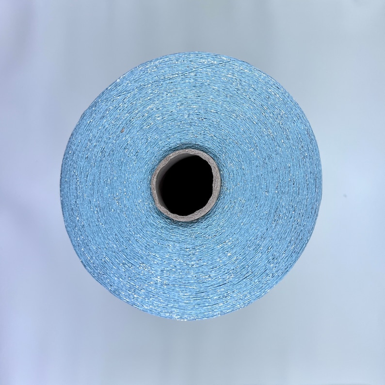 May include: A spool of light blue thread with a subtle shimmer.