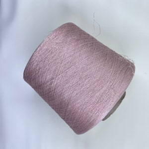 May include: A spool of light pink yarn with a subtle shimmer.
