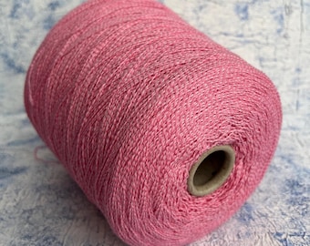 May include: A pink ball of yarn, wound on a cardboard spool.