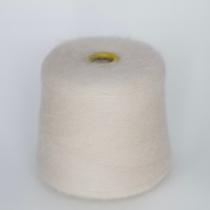 Puede incluir: Un cono de hilo beige p&aacute;lido con un centro amarillo.
