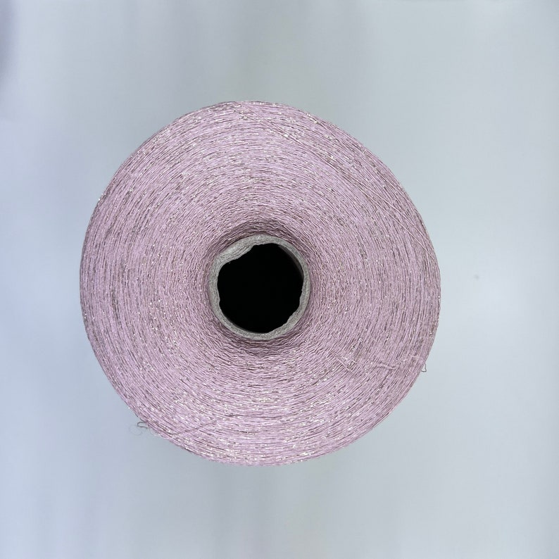 May include: A spool of light pink yarn with a shimmery finish.