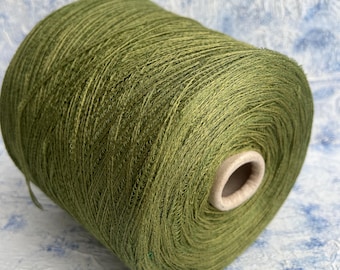 May include: A spool of green yarn, wound tightly and ready for knitting or crocheting.