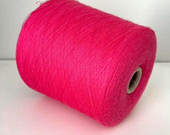 May include: A large spool of vibrant fuchsia yarn. The yarn is tightly wound, showing the texture of the fibers. The spool has a cardboard core. Ideal for knitting, crocheting, or other fiber arts projects.