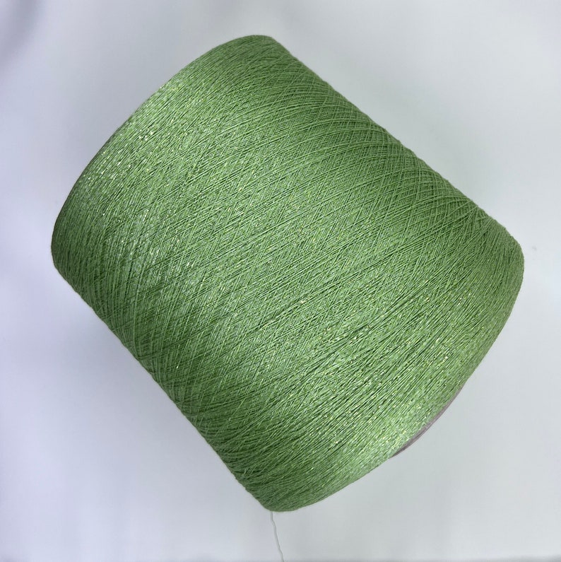 May include: A spool of green yarn with a shimmery finish.