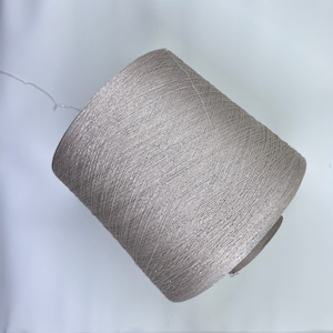 May include: A spool of silver metallic yarn.