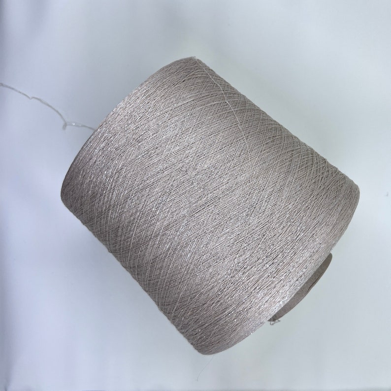 May include: A spool of silver metallic yarn.