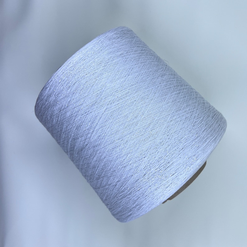 May include: A spool of white yarn with a subtle shimmer.