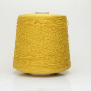 May include: A large, conical spool of vibrant yellow yarn. The thread is wound tightly around the central core, creating a smooth, uniform texture across the entire surface of the spool. The yellow color is consistent and bright throughout the object.