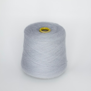 Puede incluir: Una bobina de hilo de color gris claro.
