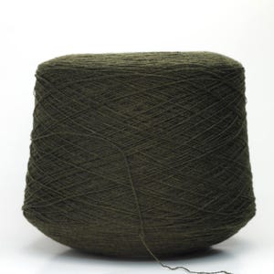 May include: A large cone of dark olive green yarn, tightly wound and ready for crafting. The yarn is a solid colour, and the cone is set against a plain white background. Ideal for knitting, crocheting, and other fibre arts projects.