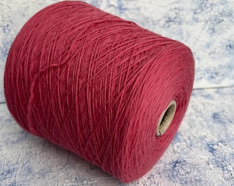 May include: A skein of deep pink yarn wound on a cardboard spool.