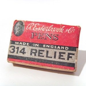 May include: A vintage red and black box of Esterbrook Co. pens. The box features the text "PENS", "MADE IN ENGLAND", and "314 RELIEF". The box has a portrait of a person on the upper left corner.