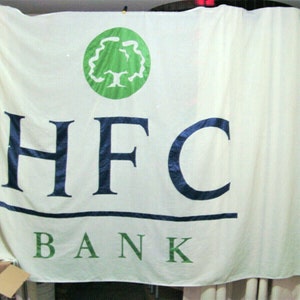 May include: A white banner with the text "HFC BANK" in blue and green letters. A green circle with a stylized tree is in the top center of the banner.