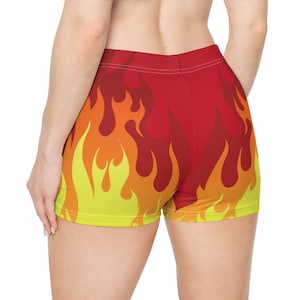 Pantalones cortos deportivos con efecto fuego, llamas, rojos, naranjas y amarillos, elásticos y de licra roja, ropa deportiva a juego.
