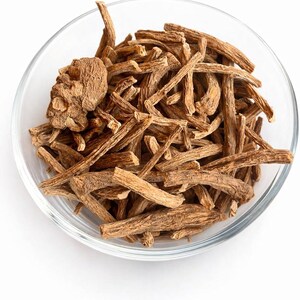 May include: A clear glass bowl filled with dried, light brown roots and root pieces. The roots vary in size and shape, with some appearing thicker and more bulbous. The background is plain white.