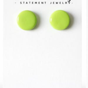 May include: A pair of lime green stud earrings on a white card. The card features the text "Admire Me Edge - Statement Jewelry -" in a stylish script font. The website address www.admiremeedge.com is at the bottom.