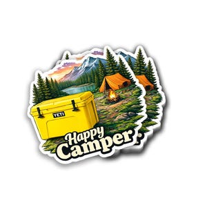 May include: A sticker featuring a yellow cooler with the brand name "YETI", a campsite scene with orange tents, a campfire, and a mountain landscape. The text "Happy Camper" is displayed in a white font with a black outline.