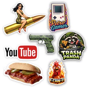 May include: A collection of stickers featuring various designs. Includes a woman riding a bullet, a retro handheld game console, a camouflaged handgun, a raccoon in a trash can, a YouTube logo, a sandwich, and a rooster with the text "F-CAW-F!".