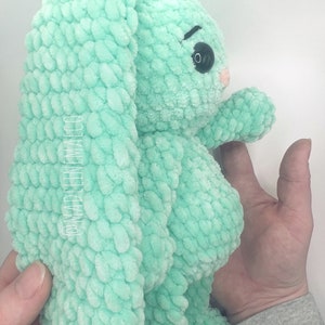May include: A crocheted plush toy bunny in a light green color. The bunny has large floppy ears and a sweet expression.
