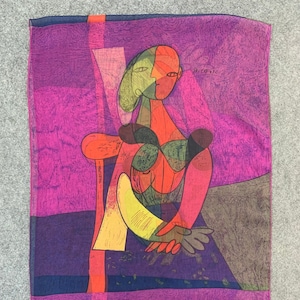 Puede incluir: Una colorida bufanda de seda con un diseño geométrico que presenta a una mujer en una silla. La bufanda está impresa con la firma del artista "Picasso".