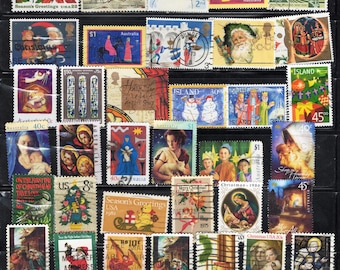 May include: A collection of various postage stamps featuring Christmas and holiday themes, including depictions of the Nativity, Santa Claus, snowmen, angels, and religious figures, arranged in rows within a black stamp album page.