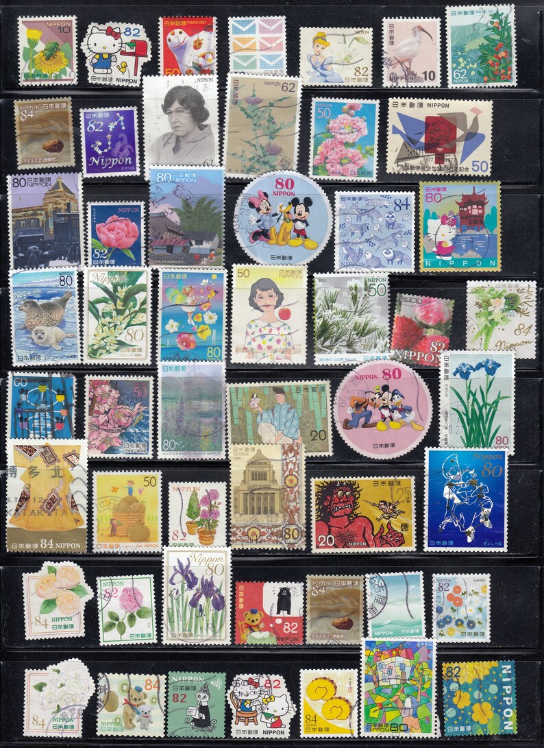 Puede incluir: Una colecci&oacute;n de coloridos sellos postales japoneses, con varios dise&ntilde;os. Los sellos representan flores, retratos, personajes de dibujos animados y paisajes. Los sellos est&aacute;n dispuestos sobre un fondo negro.