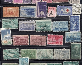 May include: A collection of vintage United States postage stamps, showcasing various designs and denominations. The stamps depict historical events, landmarks, and figures, including the International Geophysical Year and the International Red Cross. The stamps are displayed in a black sheet.