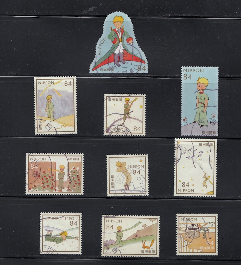 May include: A collection of Japanese postage stamps featuring illustrations of The Little Prince. The stamps depict various scenes from the story, with the text "NIPPON" and the value "84" printed on each. The stamps are in various shapes and sizes.