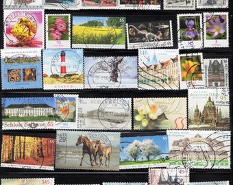 May include: A collection of colorful German postage stamps, featuring various designs. The stamps depict flowers, buildings, landscapes, and historical figures. Denominations are visible, ranging from 5 to 145.