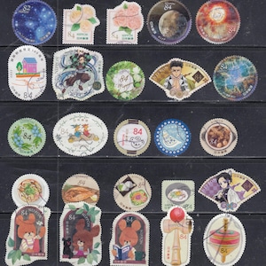 Może przedstawiać: Kolekcja kolorowych japońskich znaczków pocztowych. Znaczki przedstawiają różne wzory, w tym ciała niebieskie, kwiaty, postacie z anime, jedzenie i misie. Każdy znaczek ma numer "84".