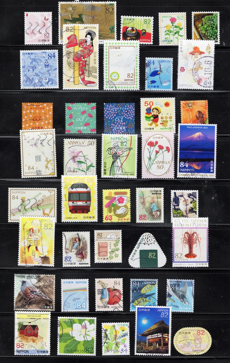 Puede incluir: Una colecci&oacute;n de varios sellos postales japoneses dispuestos en filas, con diversas ilustraciones que incluyen paisajes, animales, figuras culturales, trenes y dise&ntilde;os florales, cada uno marcado con su valor en yenes.
