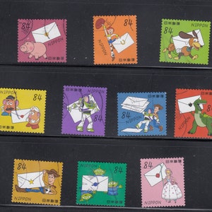 Può includere: Nove francobolli colorati con personaggi del franchise Toy Story. Ogni francobollo presenta un personaggio diverso che tiene una busta. I francobolli sono del Giappone e presentano il testo "NIPPON" e "84" su ogni francobollo.