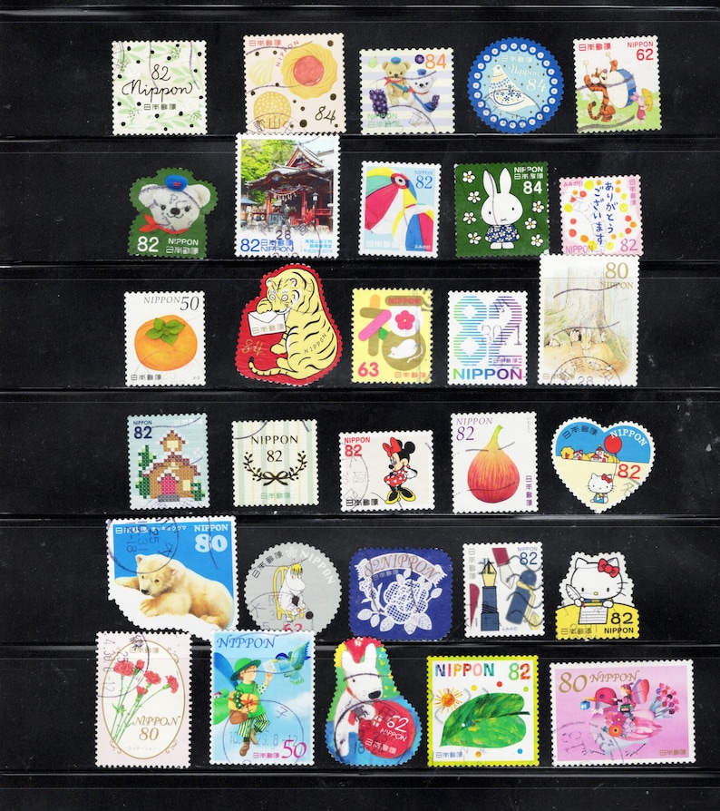 Puede incluir: Una colecci&oacute;n de varios sellos postales japoneses dispuestos en filas, con diversas ilustraciones que incluyen animales, frutas, flores, personajes de dibujos animados y escenas tradicionales, con denominaciones como 50, 62, 63, 80, 82 y 84.