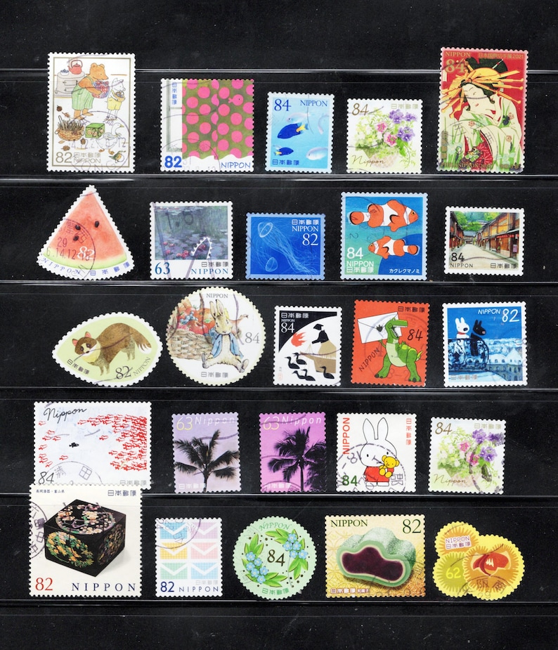 Puede incluir: Una colecci&oacute;n de veinticuatro sellos postales japoneses dispuestos en cinco filas. Los sellos presentan diversas ilustraciones que incluyen animales, flores, comida, paisajes y motivos culturales, con valores de 62, 63, 82 y 84.